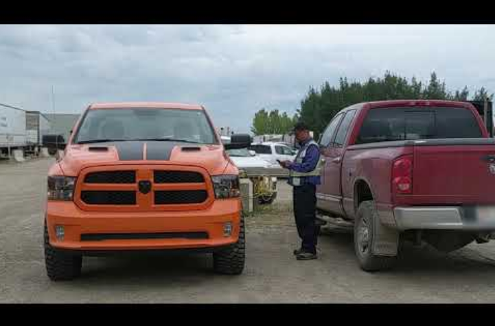 two pickup trucks are parked in a parking lot