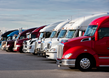 Side view of a line of semi trucks on a parking lot