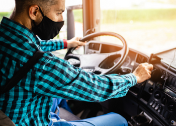 Man wearing a mask driving a semi truck Man wearing a mask driving a semi truck