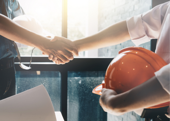 Carrier shaking hands with OHS worker holding a hardhat